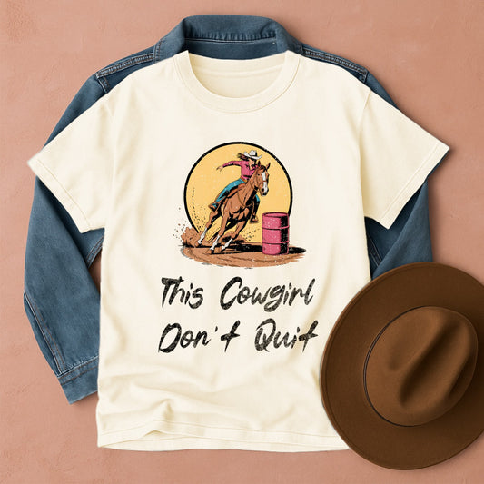 T-shirt with a Barrel Racing cowgirl graphic and text, denim jacket, and brown hat on a beige background