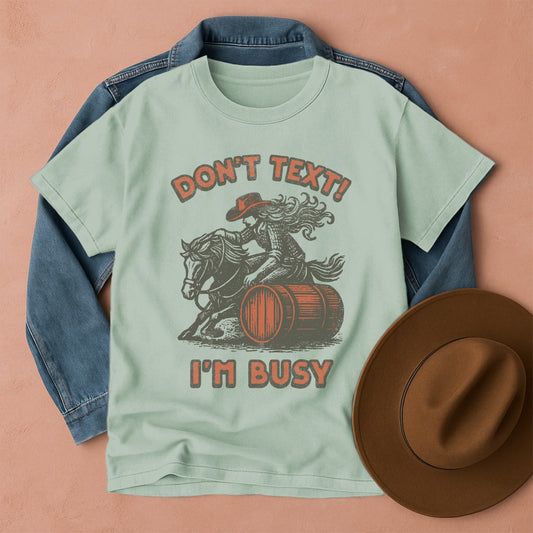 Comfort Colors T-shirt with graphic design featuring a cowgirl on a horse barrel racing, Front view