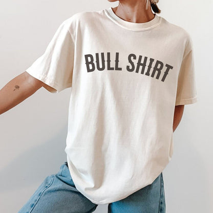 Oversized Comfort Colors tee with 'BULL SHIRT' text and blue jeans on a plain background