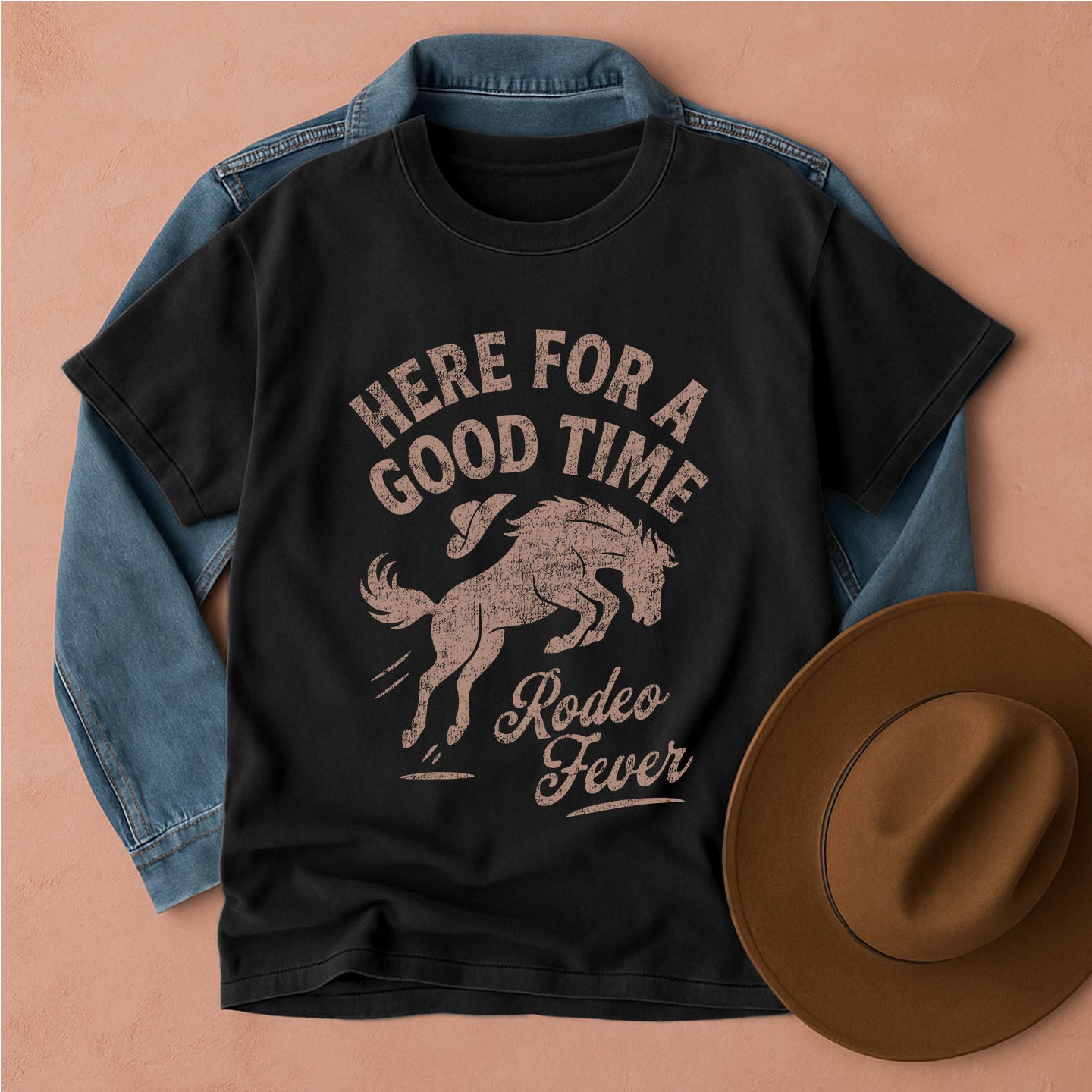 Black t-shirt with 'Here for a Good Time Rodeo Fever' graphic, denim jacket, and brown hat on a beige background