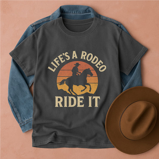 Gray t-shirt with 'Life's a Rodeo, Ride It' graphic on a peach background