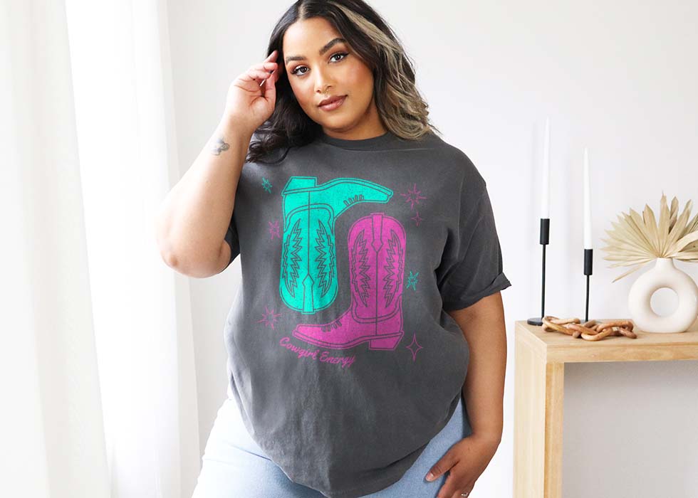Woman wearing a Comfort Colors 1717 tee in Pepper with cowgirl boots graphic design